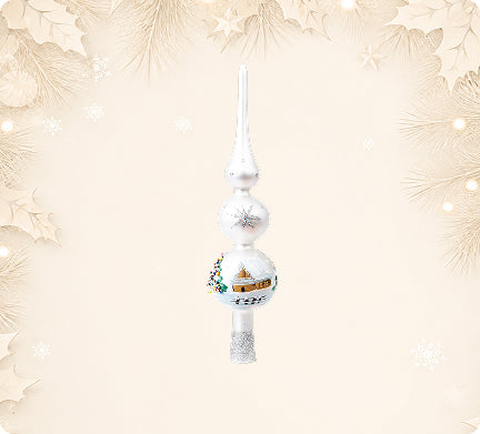 White glass tree topper painted with a village